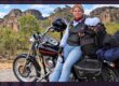 Kerri leaning against her loaded touring motorcycle on the way to Kakadu National Park
